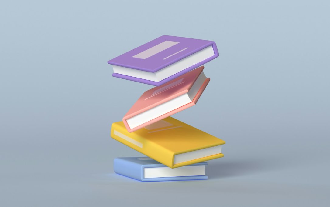 Bücher Vier schwebende Bücher in verschiedenen Farben auf einem hellblauen Hintergrund.